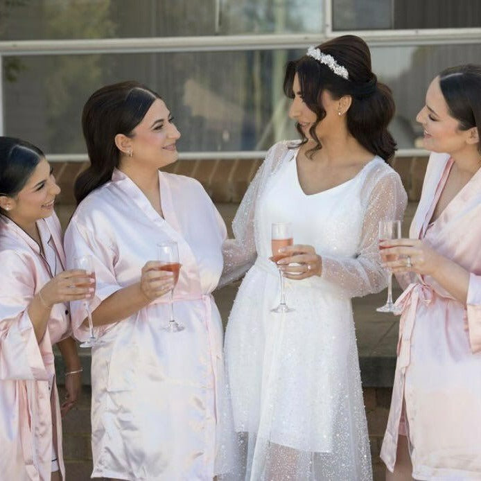 Bride wearing sequins bridal robe with bridesmaids