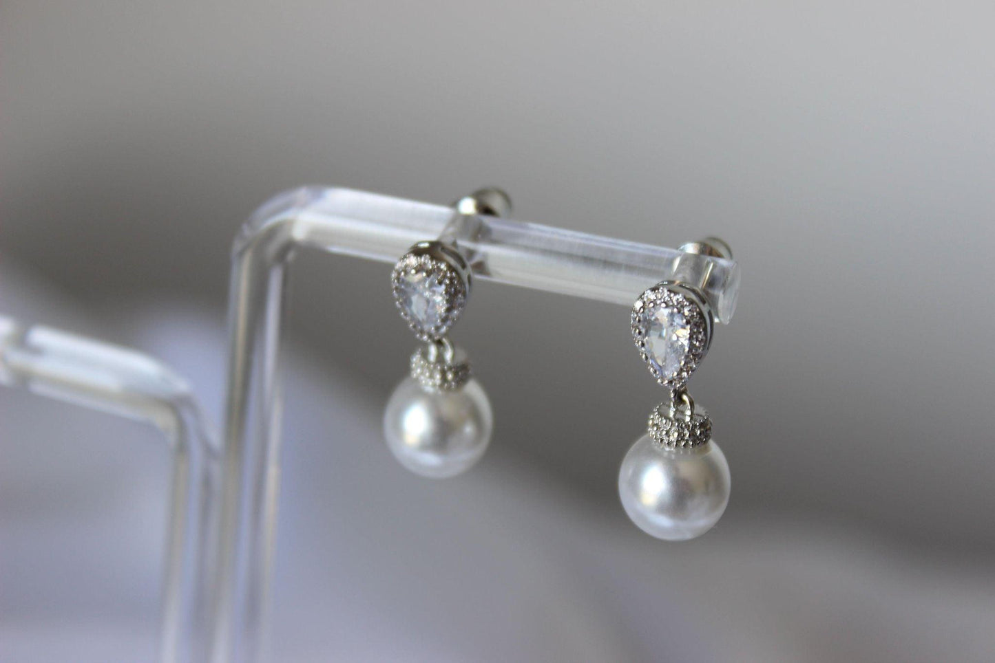 Close up of Bianca Mini Pearl Drop Earrings on earring stand