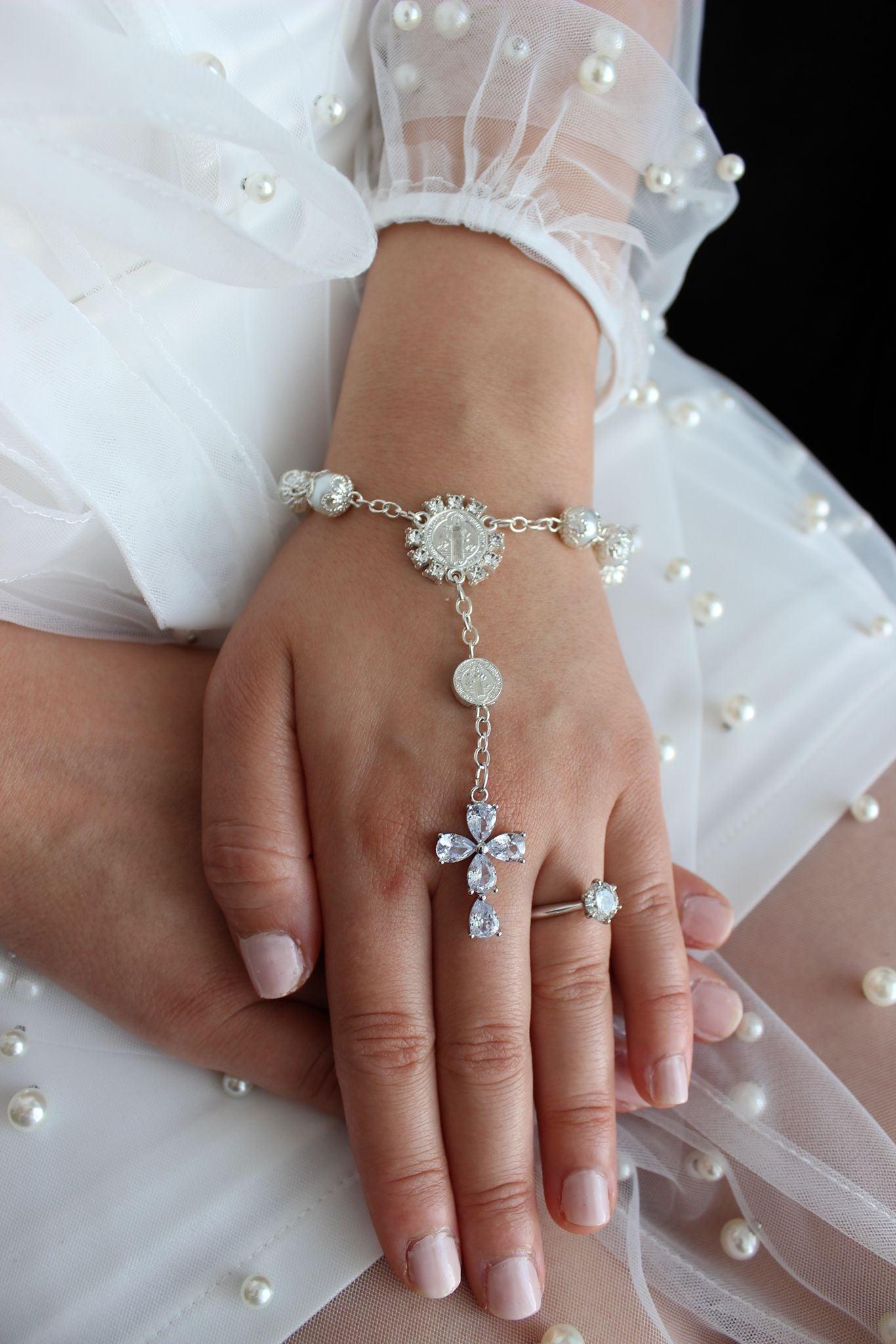 Bridal rosary bracelet with marquise cross worn on bride’s hand, hands gently crossed