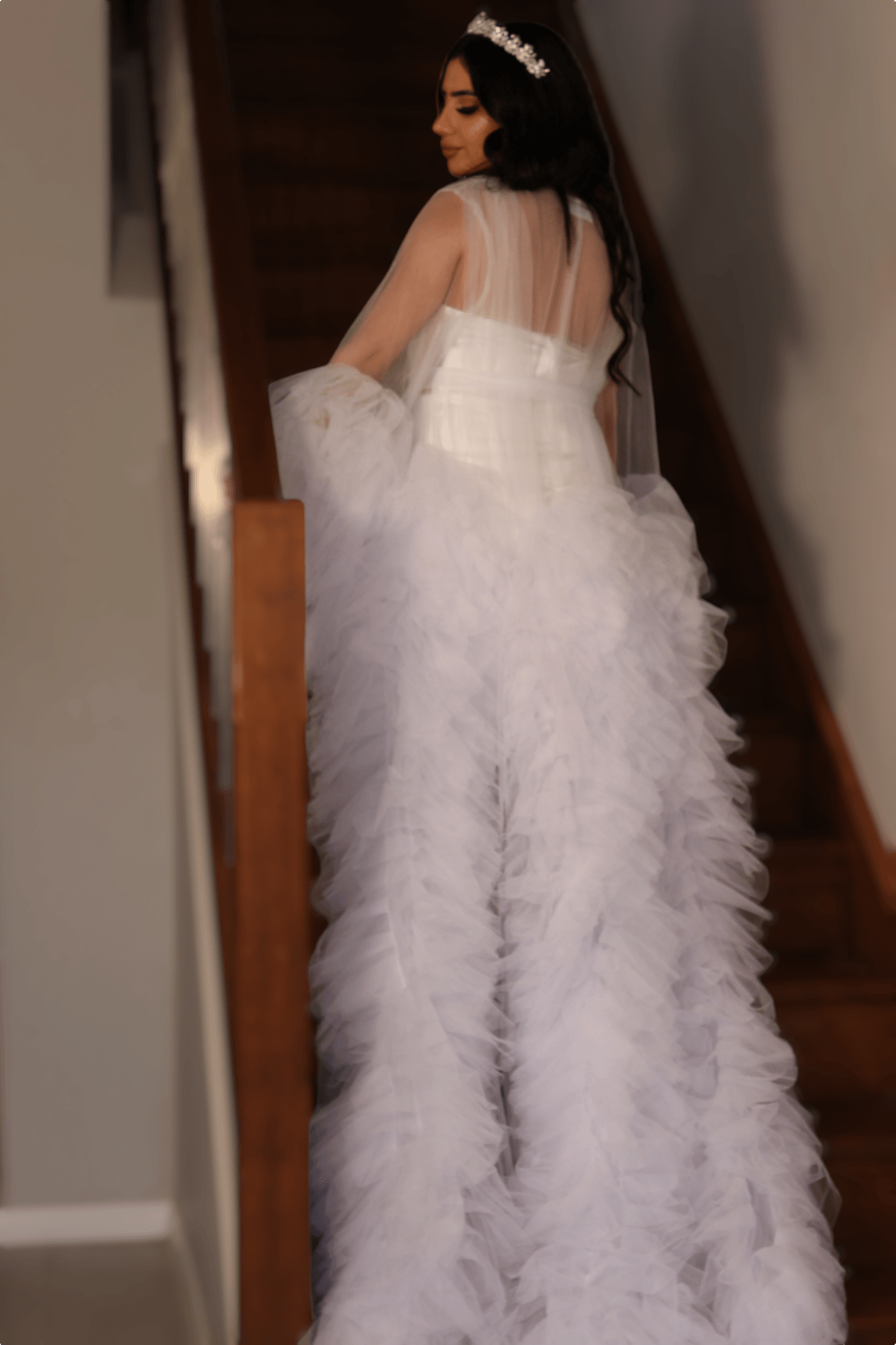 Bride walking down stairs in a fluffy butterfly bridal robe