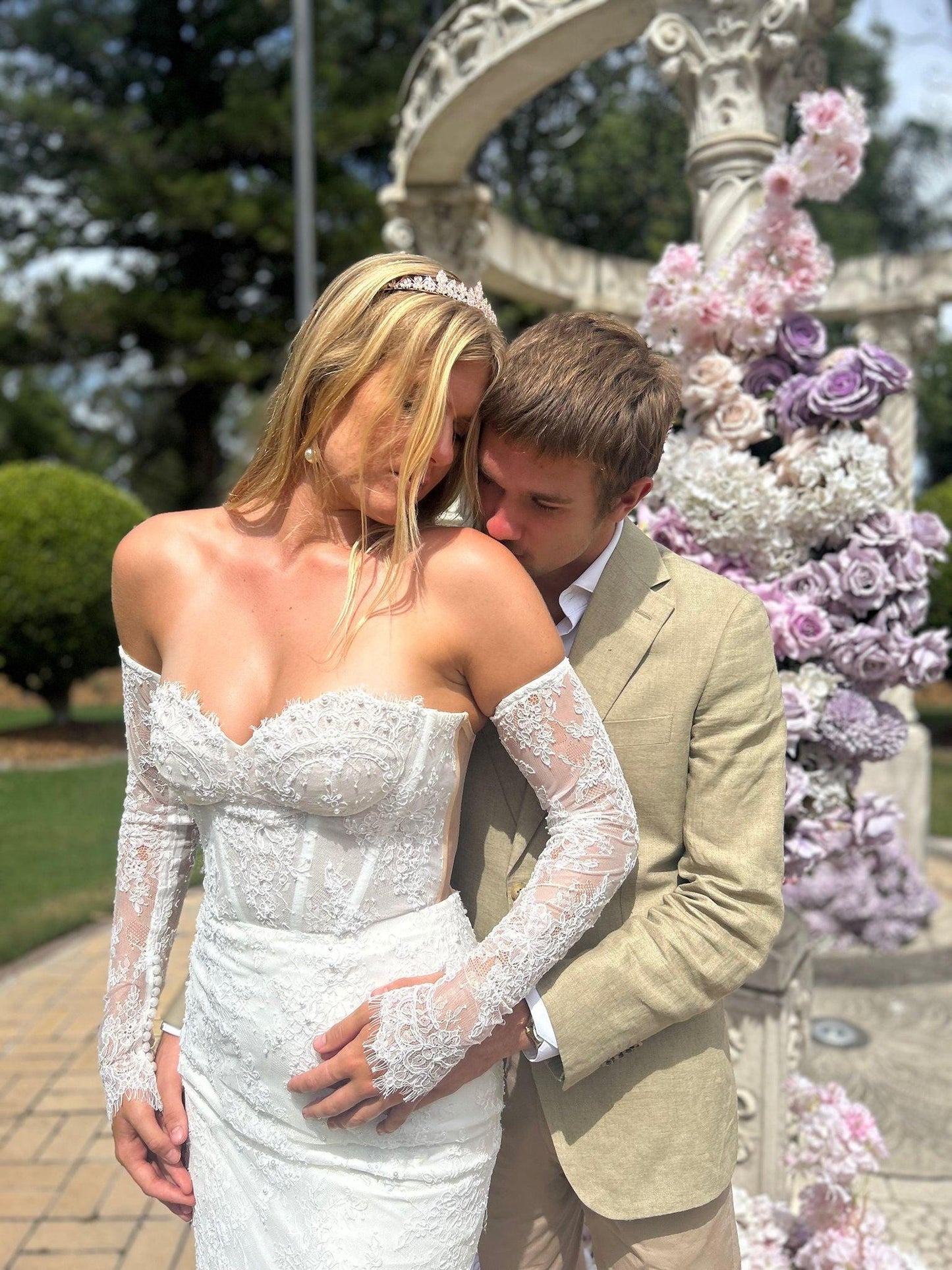 ride wearing rose gold bridal tiara posing with groom in park