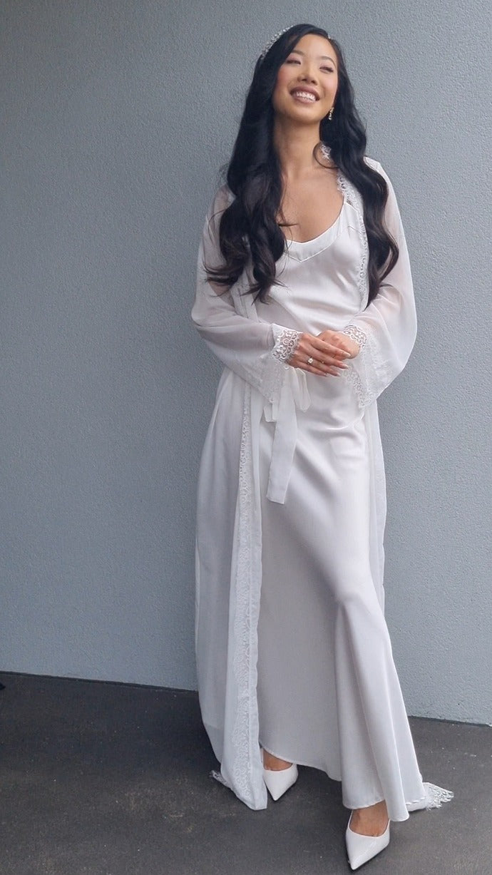 bride wearing lace bridal robe outside house