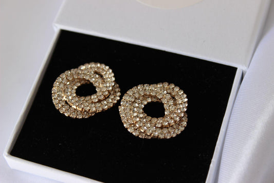 Large bridal swirl gold earrings on white background