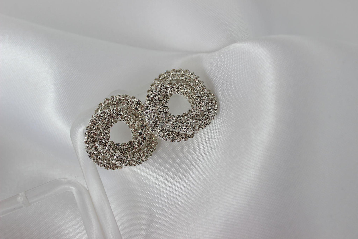 Large bridal swirl silver bridesmaid earrings on white cloth