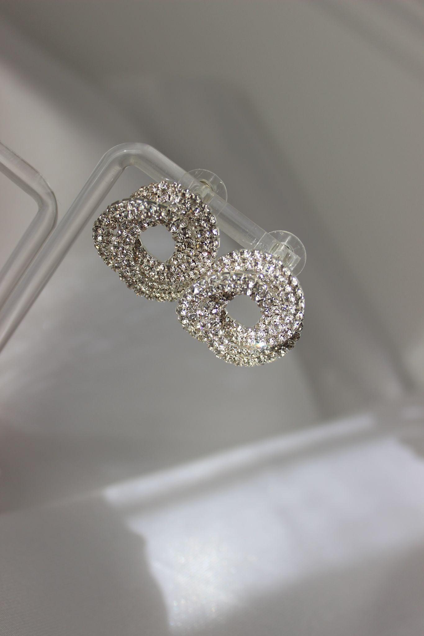 Large bridal swirl silver bridesmaid earrings on earring stand