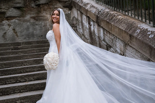 Bride seen from behind wearing a long wedding veil draped down her back
