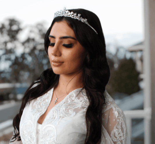 Bride wearing a headpiece posing eyes closed