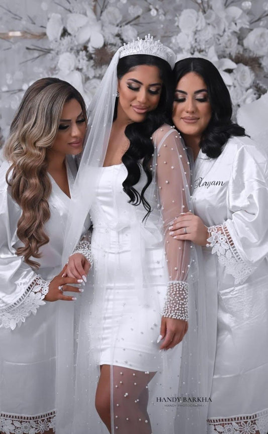 Bride wearing luxury bridal robe next to bridesmaids