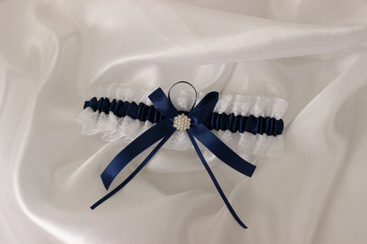 Navy blue and white lace bridal garter on white satin background