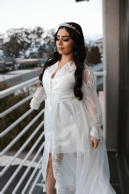 Bride wearing the Ariana Lace Robe with lace accents and poke dot details, posing gracefully on a balcony.