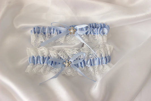 Pair of lace garters with blue ribbons on a satin background
