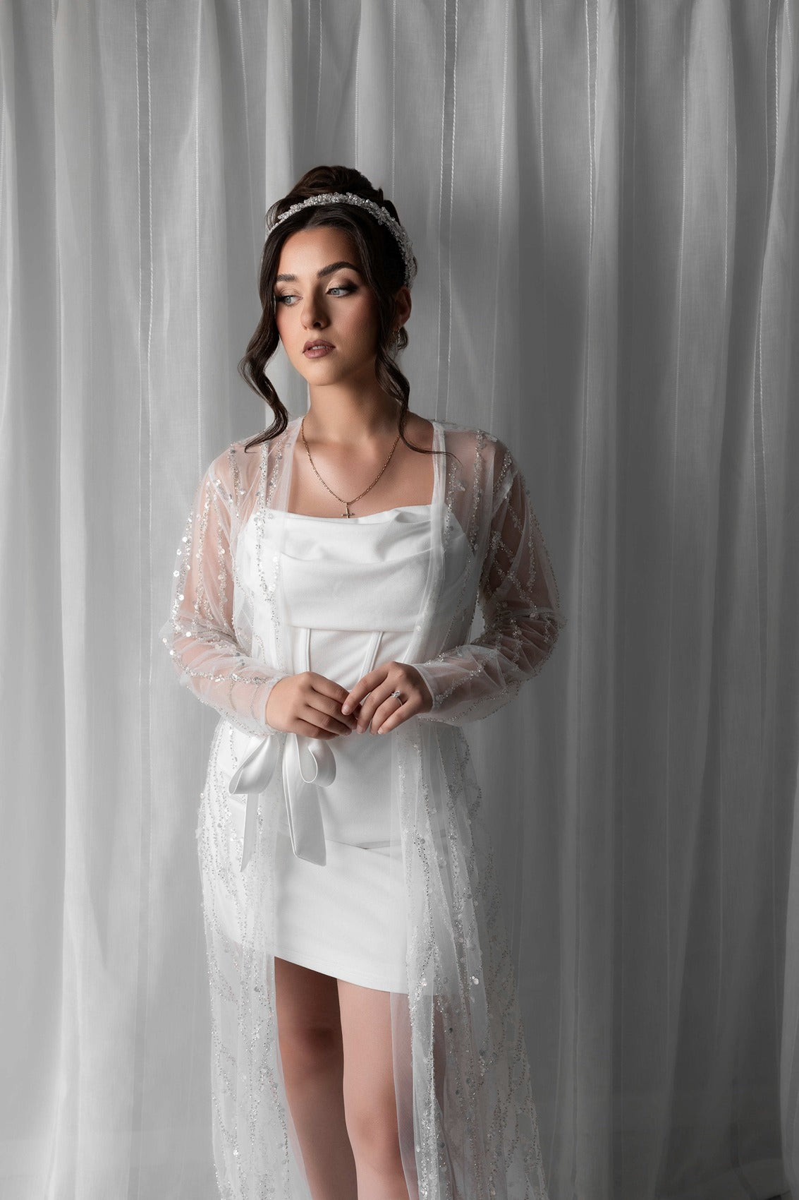Woman in a bridal robe against a plain background