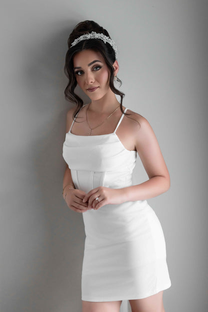 Woman wearing a white bridal slip dress against a gray background