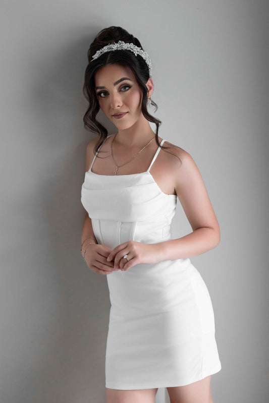 Woman wearing a white bridal slip dress against a gray background