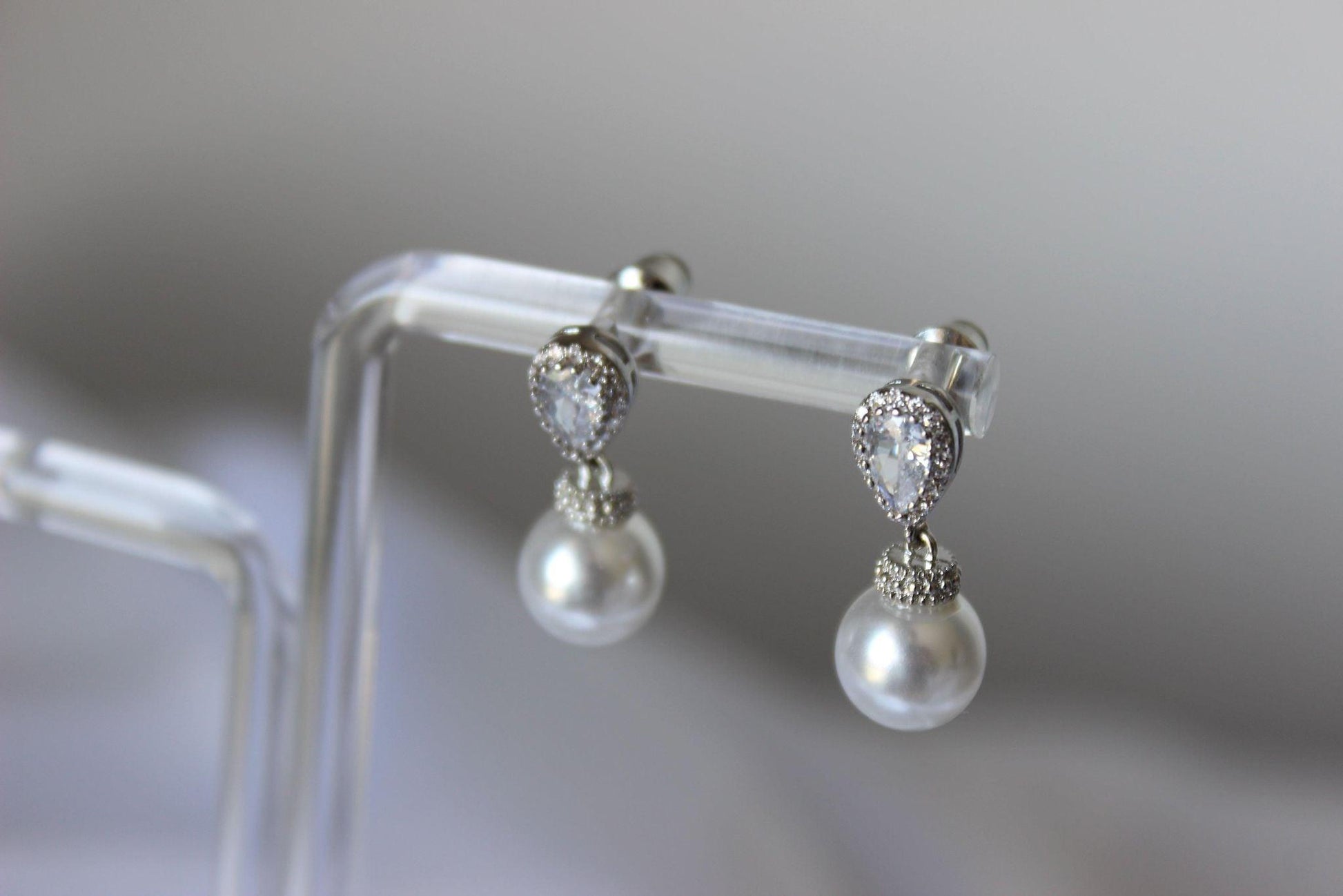 Close up of Bianca Mini Pearl Drop Earrings on earring stand