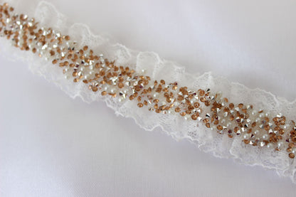 white wedding garter featuring gold embellishments