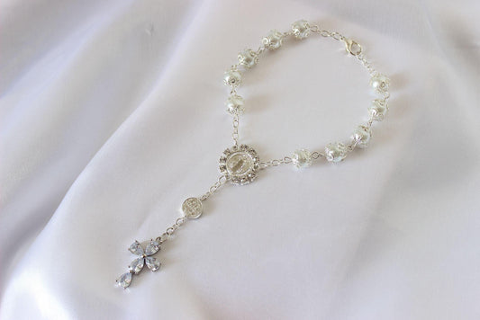 Bridal rosary bracelet with marquise cross displayed on white cloth background