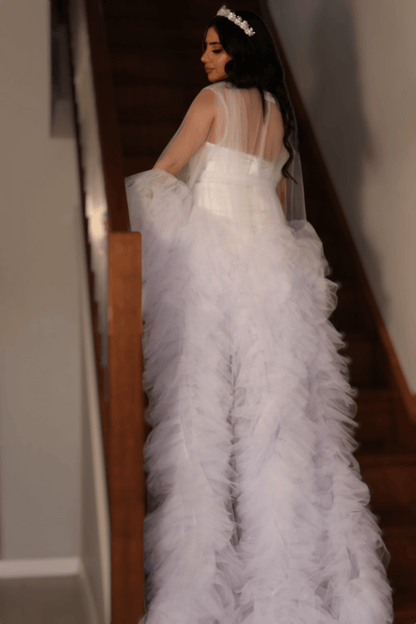 Bride walking down stairs in a fluffy butterfly bridal robe