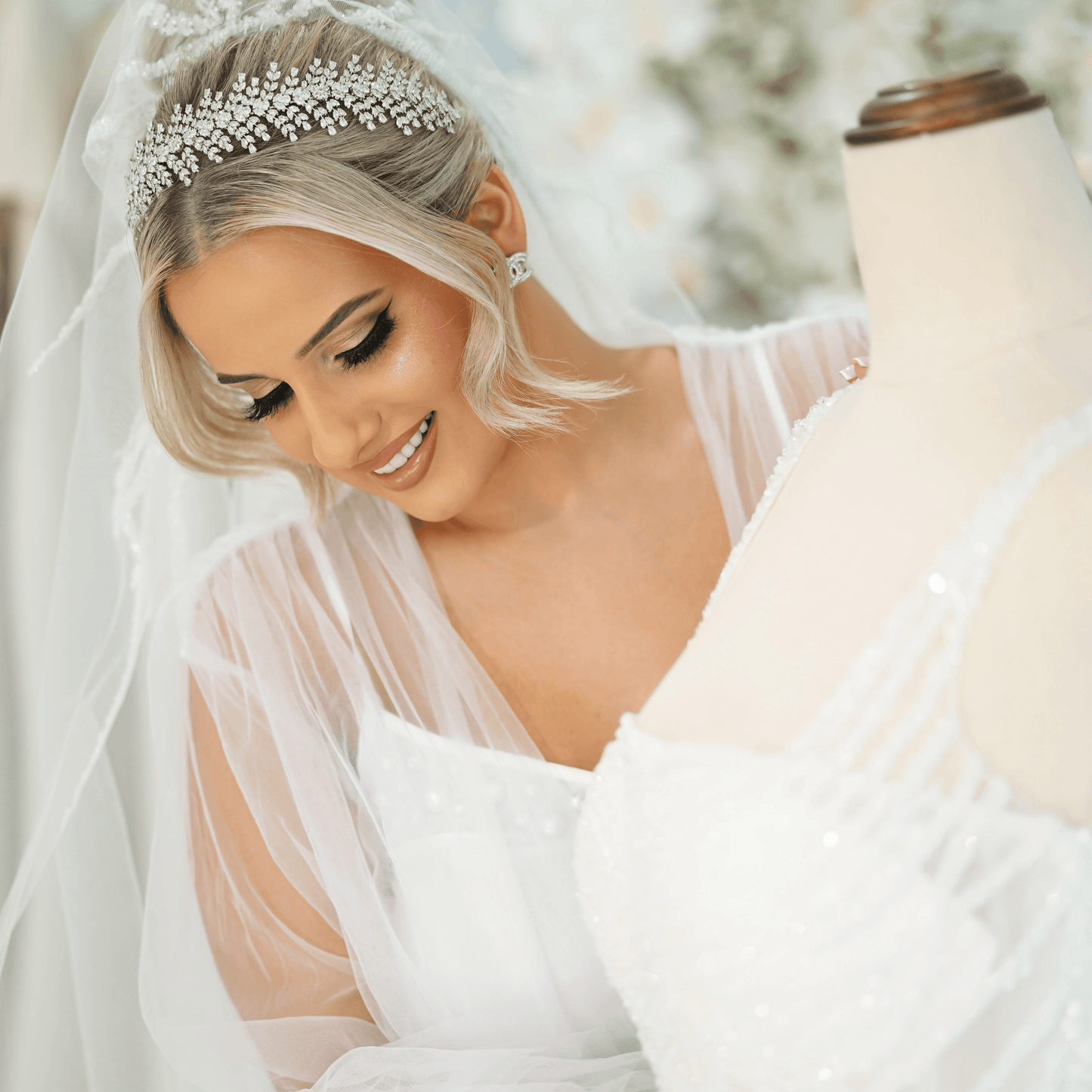Christina bridal headband displayed on mannequin as woman gently touches the wedding dress