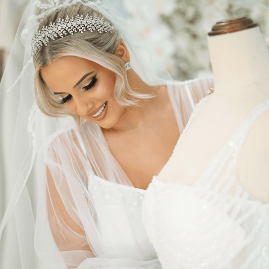 Christina bridal headband displayed on mannequin as woman gently touches the wedding dress