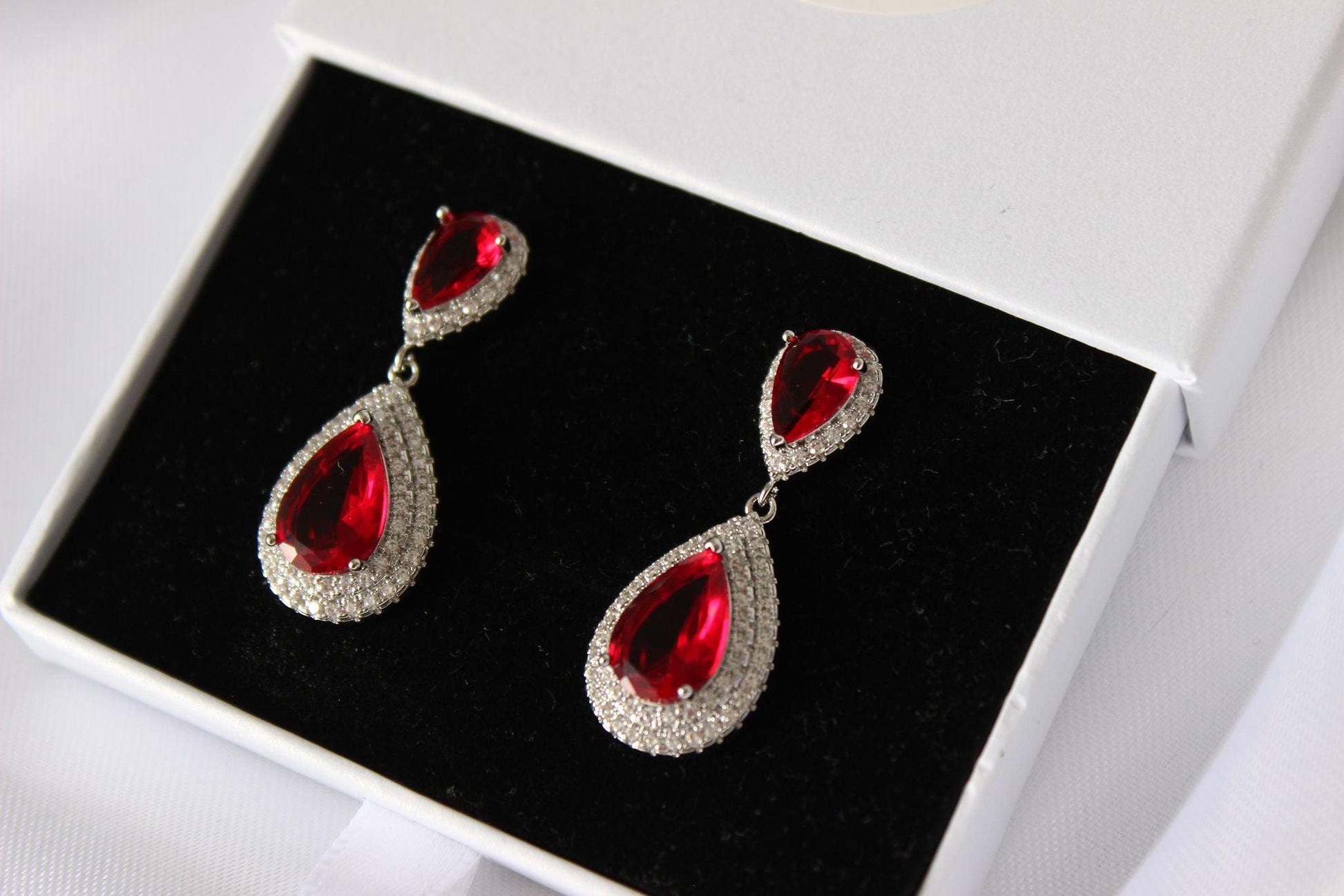 Close-up of Emily Ruby Drop Earrings in jewellery box