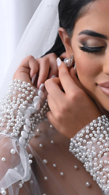 bride posing with earrings and pearl Bridal Robe