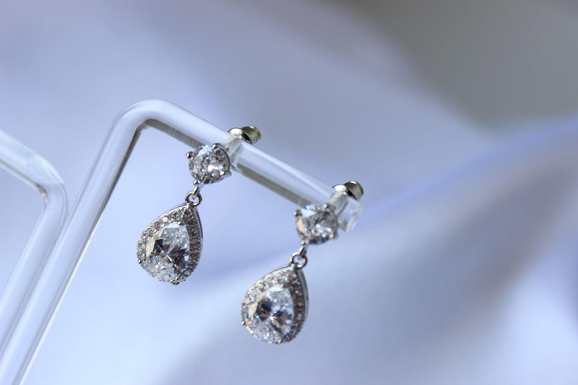 Karmela pear-shaped cubic zirconia silver drop earrings on earring stand