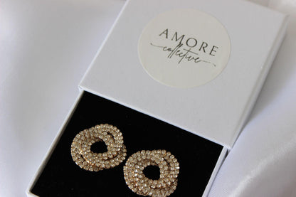 Large bridal swirl gold stud earrings on white background
