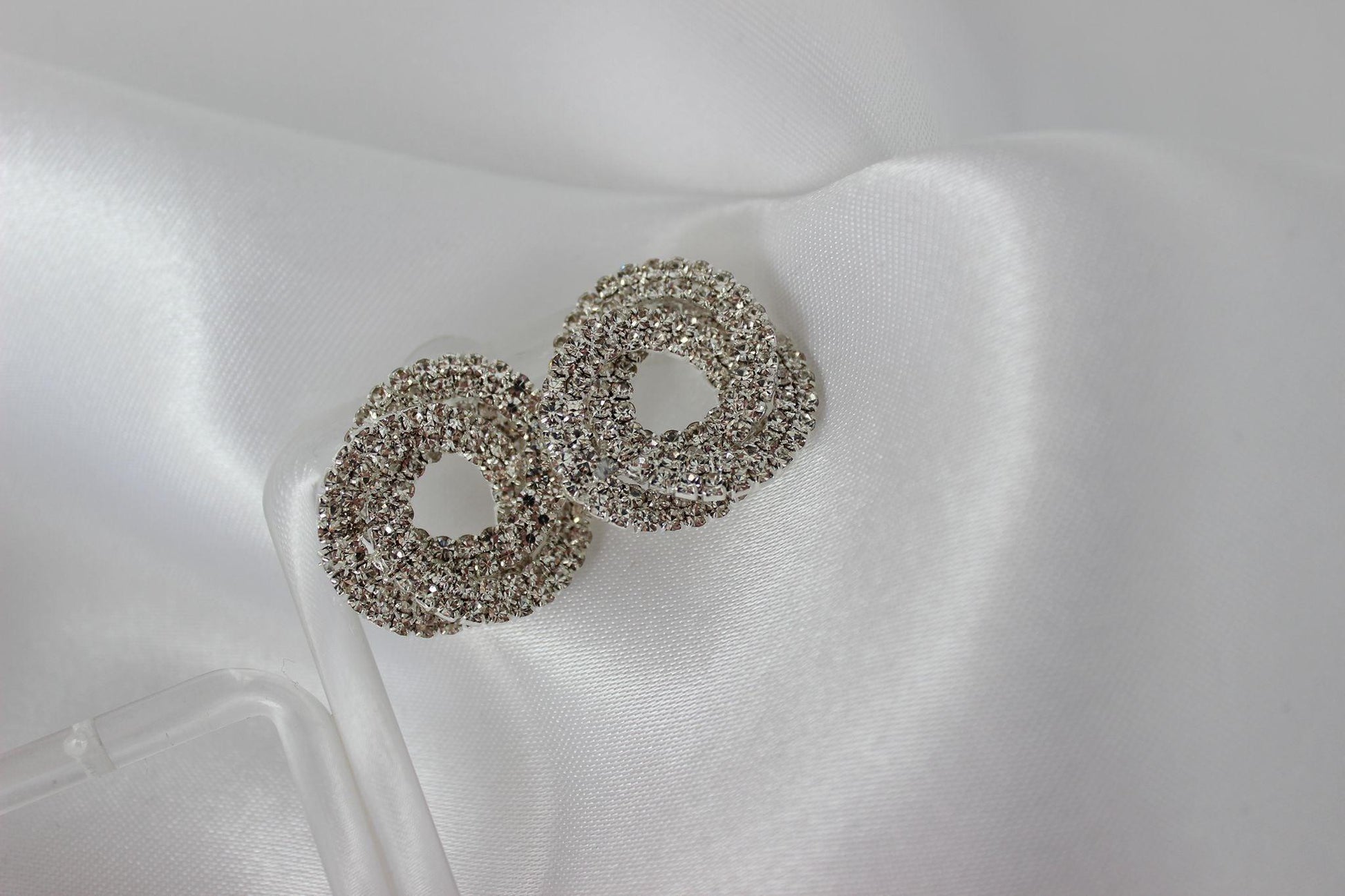 Large bridal swirl silver bridesmaid earrings on white cloth