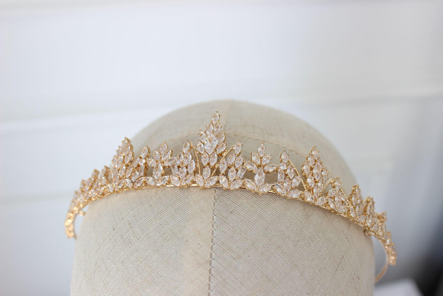 Medium gold bridal tiara with cubic zirconia crystals displayed on mannequin