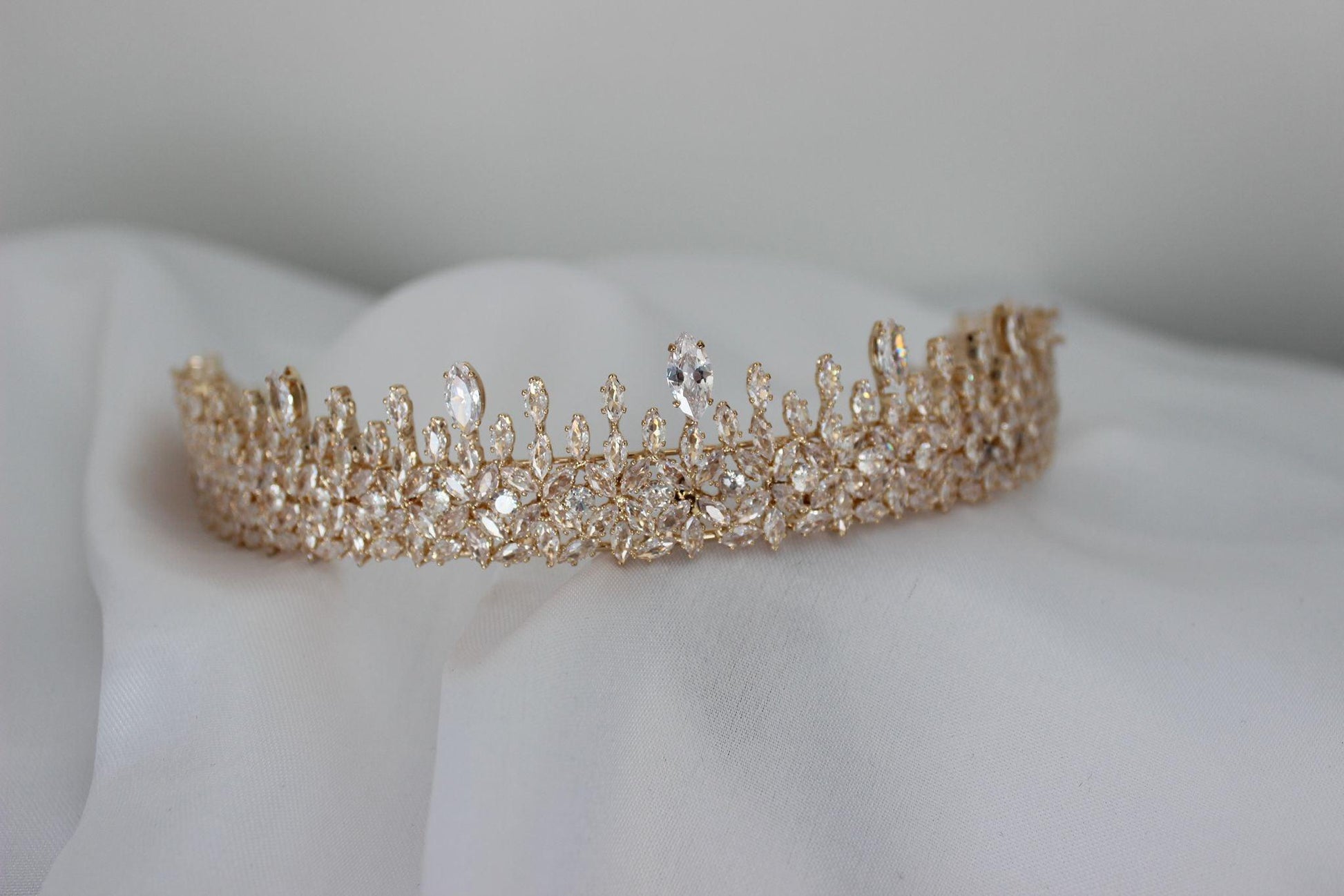 Rose gold Babylon bridal crown laid on decorative cloth
